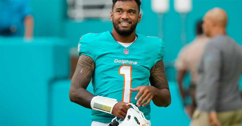 Miami Dolphins quarterback Tua Tagovailoa holding his helmet during the 2024 NFL season