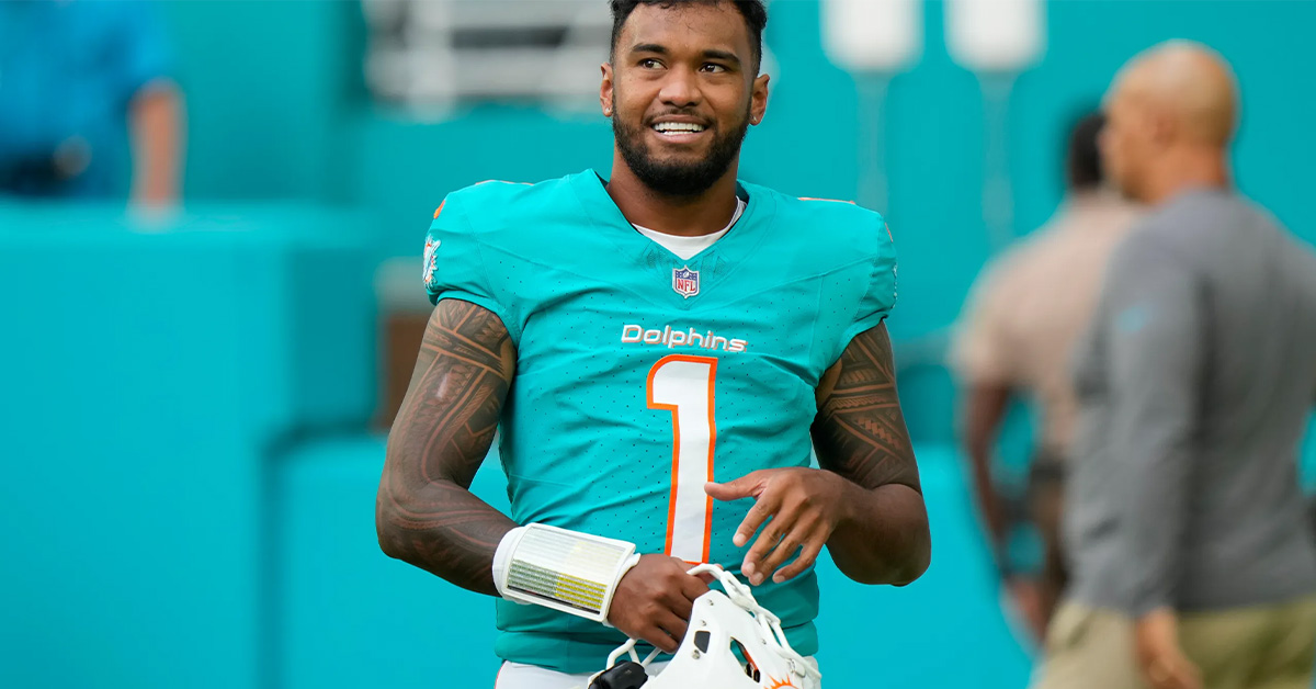 Miami Dolphins quarterback Tua Tagovailoa holding his helmet during the 2024 NFL season
