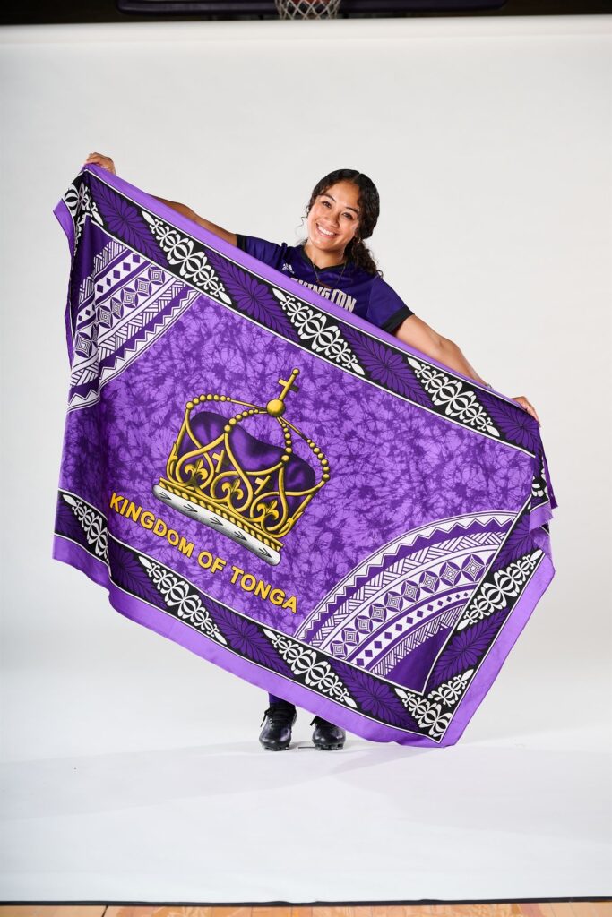 Kolo Suliafu proudly holding the Kingdom of Tonga flag in Washington Huskies gear