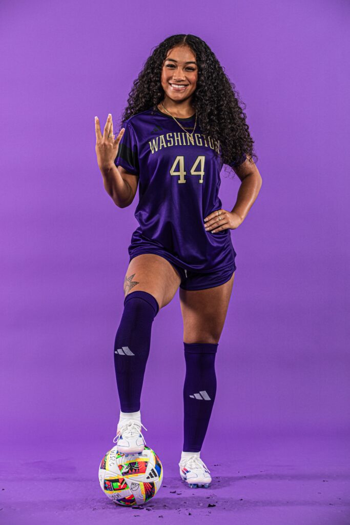 Kolo Suliafu posing in Washington Huskies soccer kit with foot on the ball