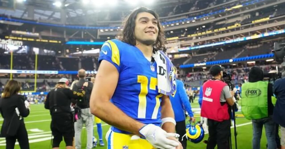 Puka Nacua smiling in Los Angeles Rams uniform at SoFi Stadium before an NFL game.