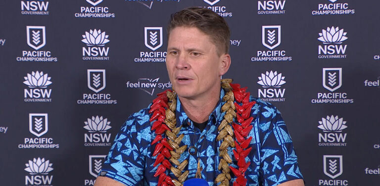 Gardiner Toa Samoa coach at 2025 Pacific Championships press conference in blue shirt with red lei against NSW Government backdrop