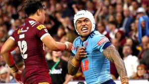 NSW Blues player Brian To'o celebrating intensely in front of QLD Maroons player Jeremiah Nanai during a State of Origin rugby league match.