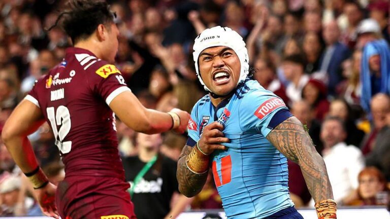 NSW Blues player Brian To'o celebrating intensely in front of QLD Maroons player Jeremiah Nanai during a State of Origin rugby league match.