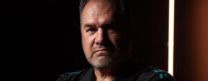 Close-up portrait of rugby coach Dave Rennie against a dark background with dramatic lighting.