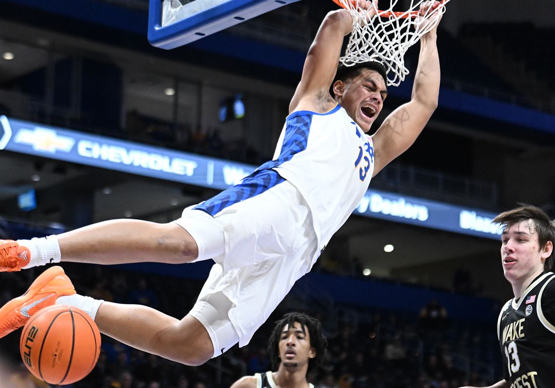 Roman Siulepa performing a powerful one-handed dunk during a high-stakes basketball game against Wake Forest.