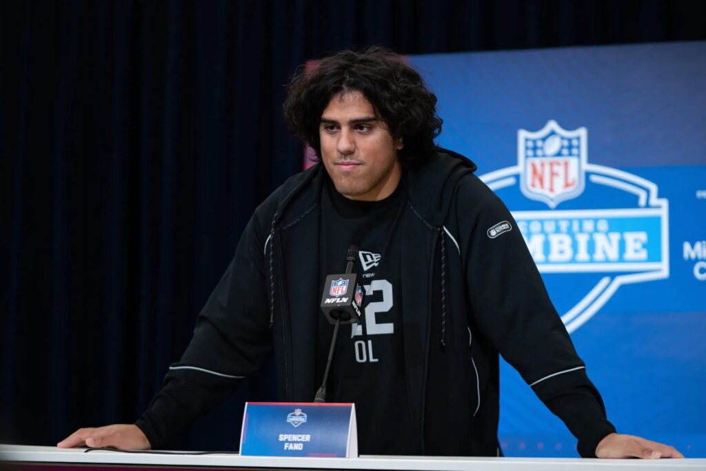 Offensive lineman Spencer Fano speaking at a podium during the NFL Scouting Combine press conference.