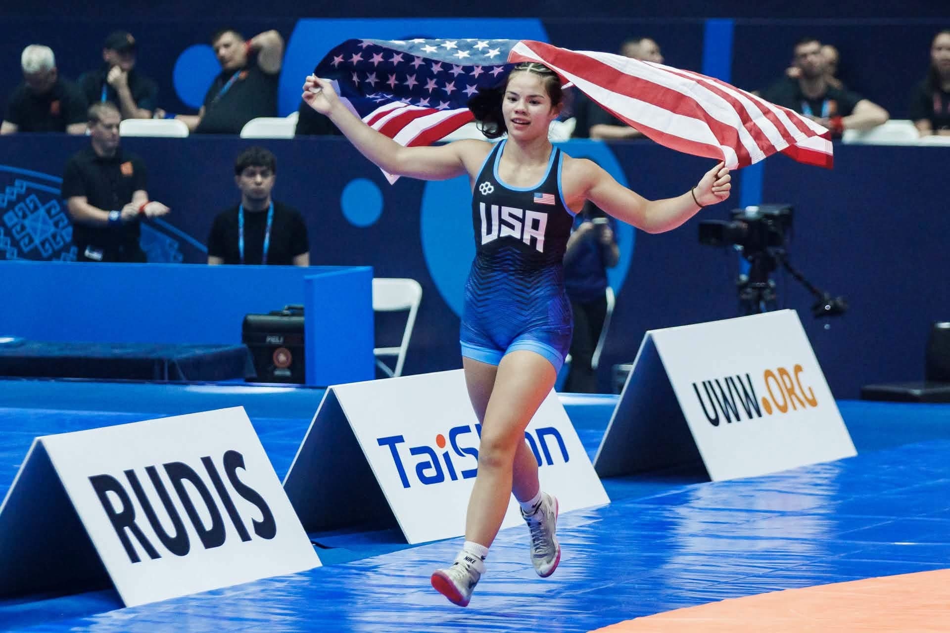 Ellison celebrates after winning the U17 World Wrestling Championships while carrying the United States flag.