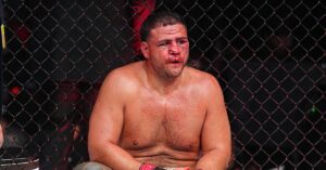 Tai Tuivasa sits against the Octagon fence, bloodied after his split decision loss to Robelis Despaigne at UFC 331 in Los Angeles